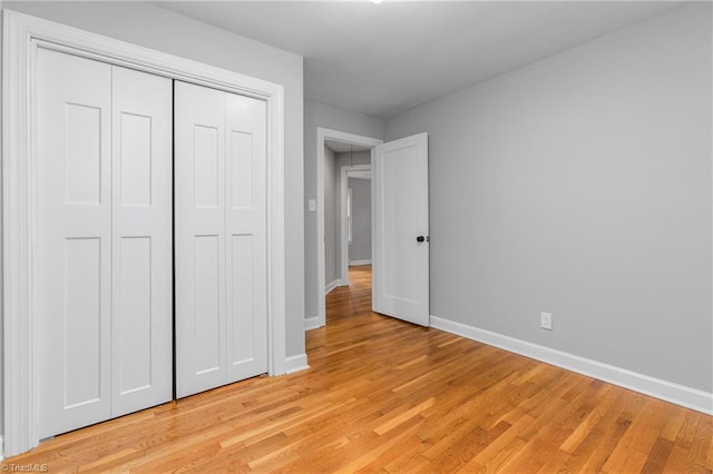 unfurnished bedroom featuring light hardwood / wood-style floors and a closet