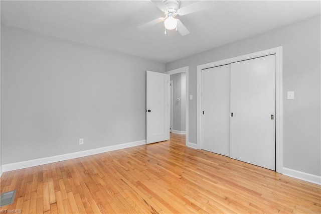 unfurnished bedroom featuring ceiling fan, a closet, and light wood-type flooring