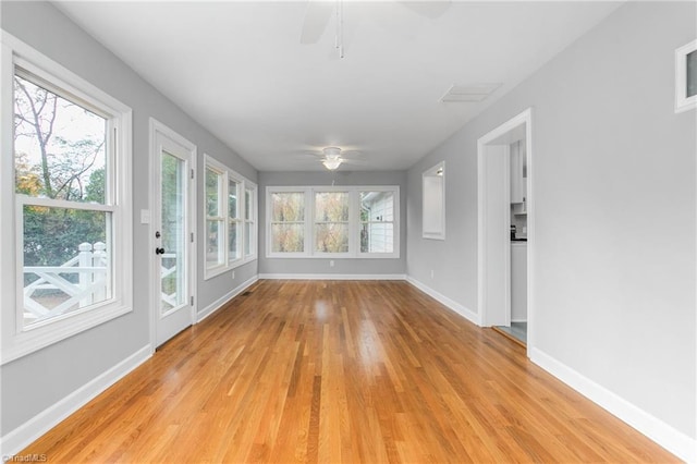 unfurnished sunroom with plenty of natural light and ceiling fan