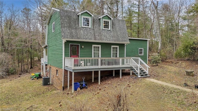 view of front facade featuring a wooden deck, central air condition unit, a gambrel roof, and a shingled roof