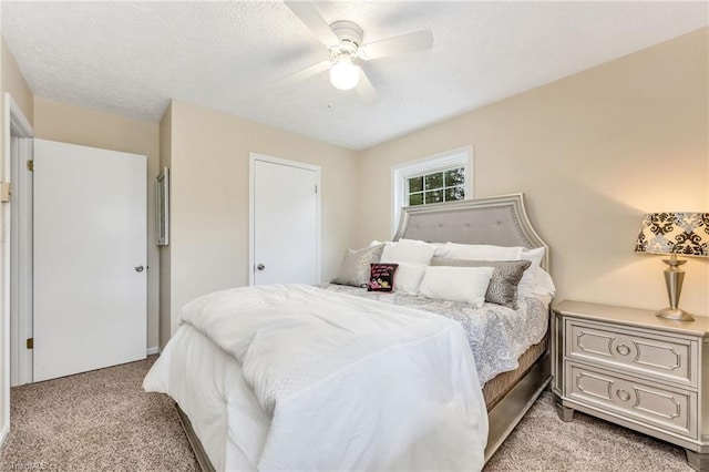 bedroom with light carpet, a textured ceiling, and ceiling fan