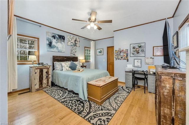 bedroom featuring crown molding, wood finished floors, baseboards, and ceiling fan