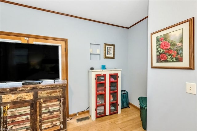 game room with visible vents, crown molding, baseboards, and wood finished floors