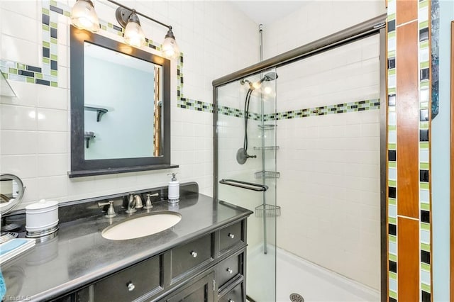 bathroom featuring vanity, tile walls, and a stall shower