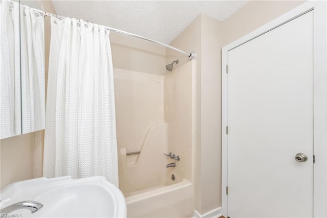 bathroom featuring a sink, a textured ceiling, and shower / bath combination with curtain