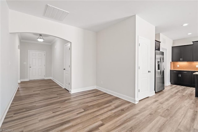 kitchen with tasteful backsplash, stainless steel fridge with ice dispenser, crown molding, and light hardwood / wood-style floors