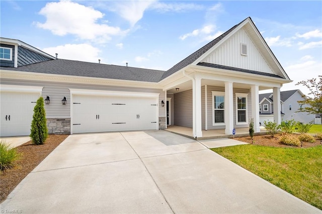 view of front of house featuring a front yard, a porch, and a garage