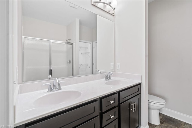 bathroom featuring vanity, toilet, and a shower with shower door