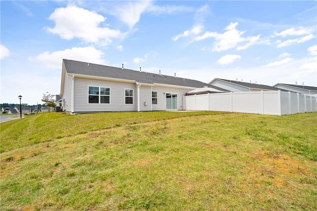 rear view of property featuring a lawn