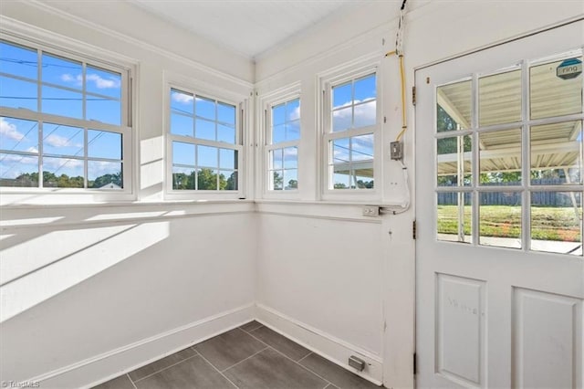 doorway to outside with dark tile patterned flooring