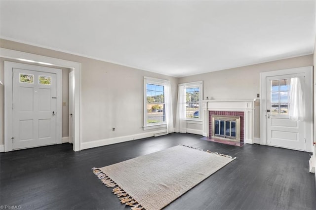 unfurnished living room with dark wood-type flooring and a brick fireplace