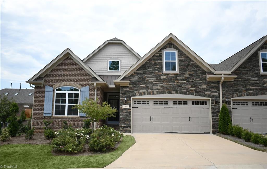 craftsman-style home with stone siding and driveway