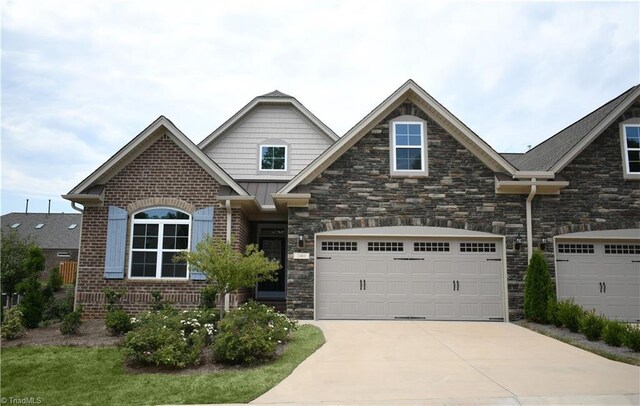 craftsman-style home with stone siding and driveway