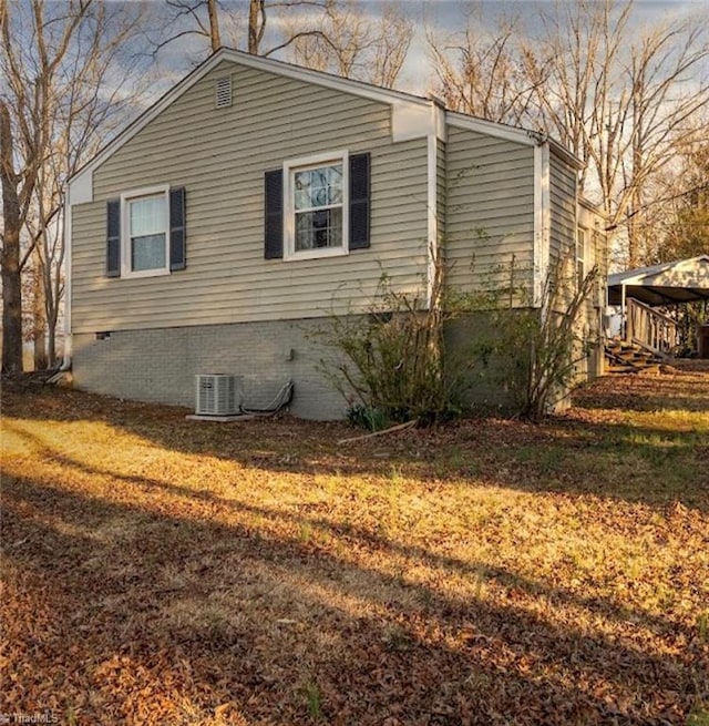 view of side of home with a lawn and central AC