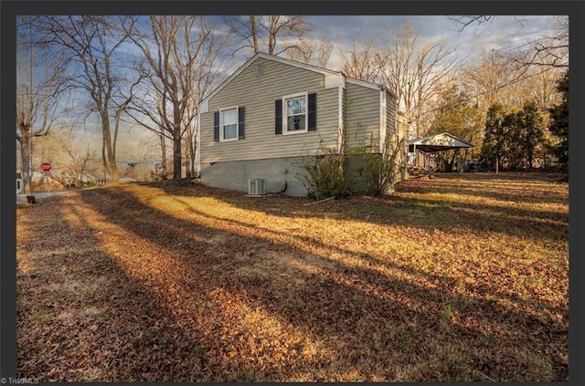 view of property exterior with a carport, a lawn, and central AC