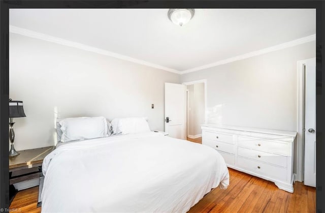 bedroom with light wood-style flooring and crown molding