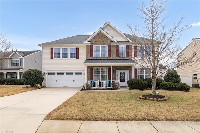 view of front of home featuring brick siding, covered porch, concrete driveway, and a front yard