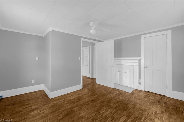 interior space with dark wood-type flooring, ornamental molding, and ceiling fan