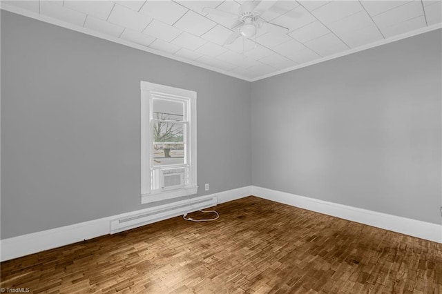 spare room featuring crown molding, ceiling fan, hardwood / wood-style floors, and a baseboard heating unit