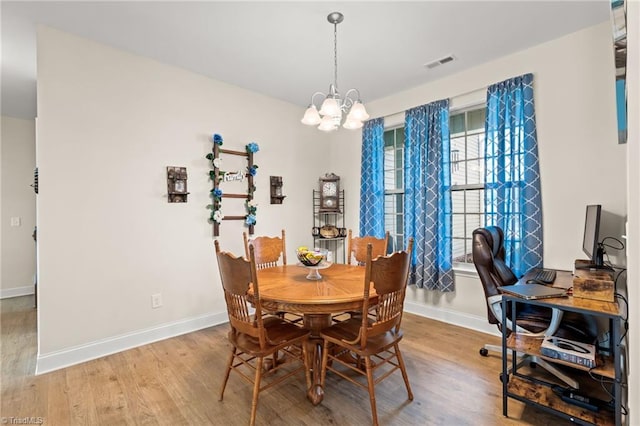 dining area featuring light hardwood / wood-style floors and an inviting chandelier