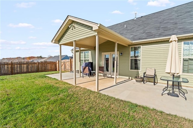 rear view of property featuring a patio and a lawn