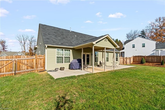 back of house featuring a lawn and a patio area