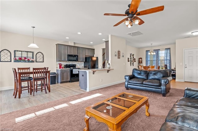 living room featuring ceiling fan and light hardwood / wood-style flooring