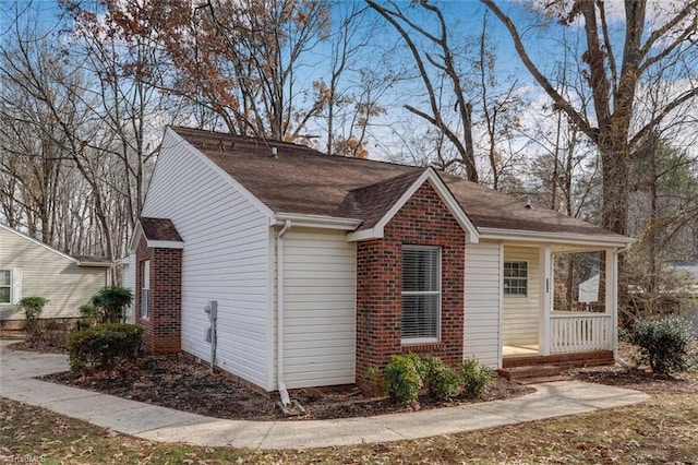 view of side of property featuring covered porch