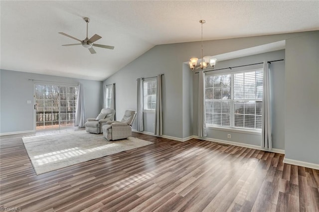 unfurnished room with hardwood / wood-style floors, ceiling fan with notable chandelier, vaulted ceiling, and plenty of natural light