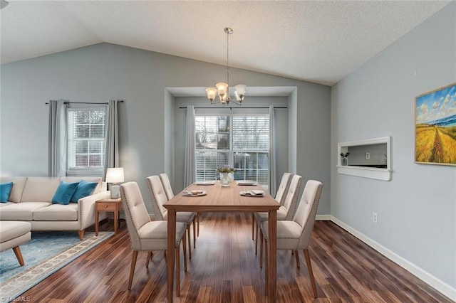 dining area with dark hardwood / wood-style flooring, an inviting chandelier, and vaulted ceiling