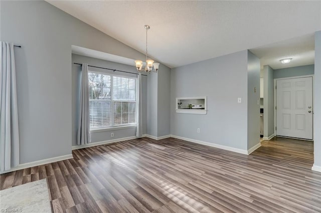 unfurnished dining area featuring hardwood / wood-style flooring, lofted ceiling, and an inviting chandelier