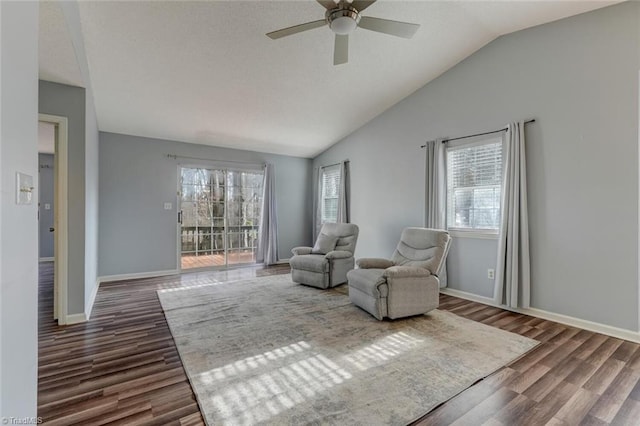 sitting room with ceiling fan, dark wood-type flooring, and vaulted ceiling