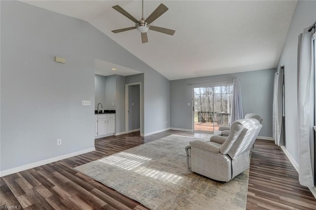 living room with dark hardwood / wood-style floors, ceiling fan, sink, and vaulted ceiling