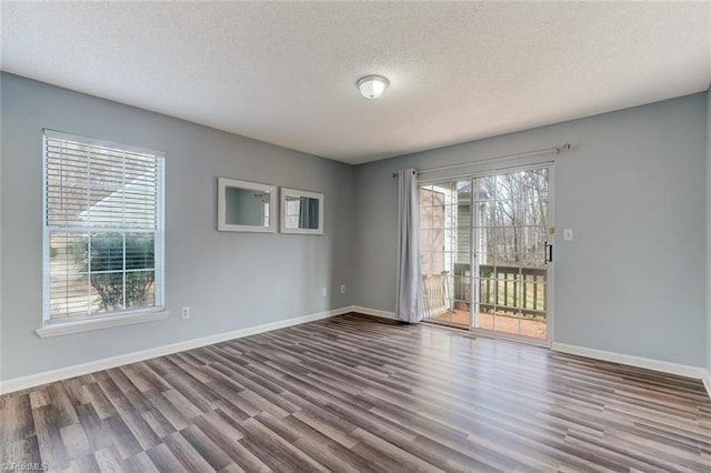 empty room with a healthy amount of sunlight, a textured ceiling, and hardwood / wood-style flooring