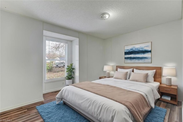 bedroom with dark hardwood / wood-style floors and a textured ceiling