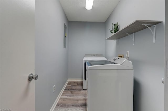 washroom with hardwood / wood-style floors, separate washer and dryer, and electric panel