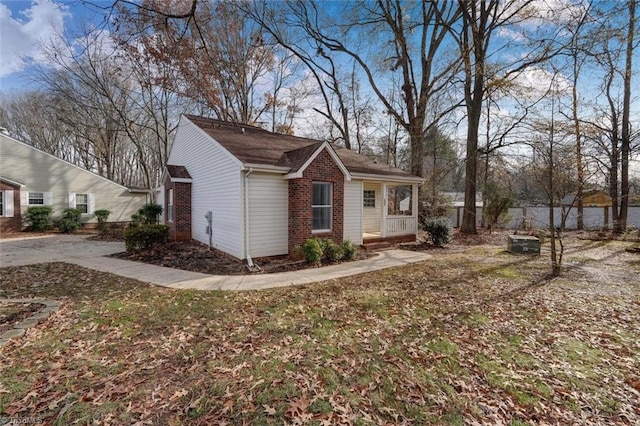 view of side of home featuring covered porch