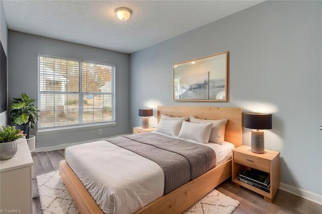 bedroom featuring light hardwood / wood-style floors and a textured ceiling