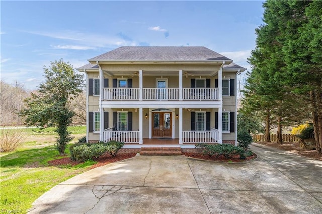 view of front facade featuring a porch, a balcony, and french doors