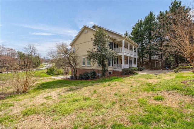 exterior space featuring a lawn, a balcony, and covered porch