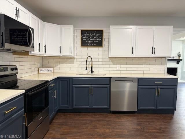 kitchen with white cabinets, sink, decorative backsplash, appliances with stainless steel finishes, and dark hardwood / wood-style flooring