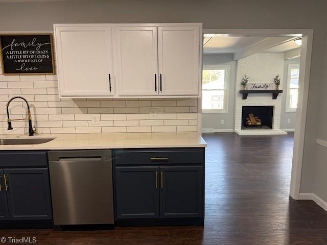 kitchen with white cabinets, sink, stainless steel dishwasher, tasteful backsplash, and dark hardwood / wood-style flooring