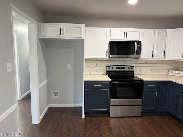 kitchen featuring backsplash, white cabinetry, dark wood-type flooring, and appliances with stainless steel finishes