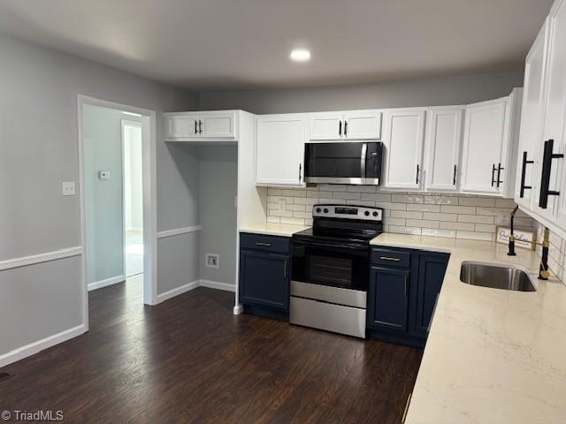 kitchen with white cabinets, sink, appliances with stainless steel finishes, and dark wood-type flooring