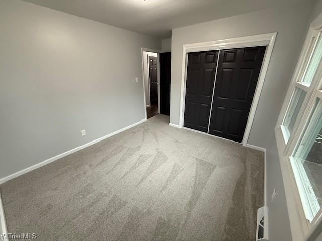 unfurnished bedroom with a closet and carpet floors