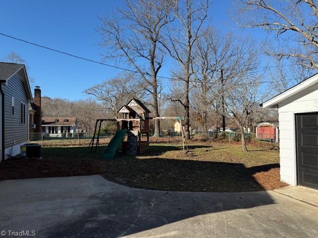 view of yard featuring a playground and central AC unit