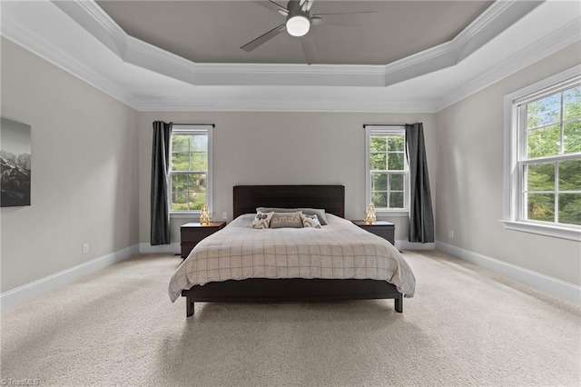 8441 Alice Player Dr, Oak Ridge, NC 27310 - bedroom featuring a tray ceiling, multiple windows, ornamental molding, and light colored carpet