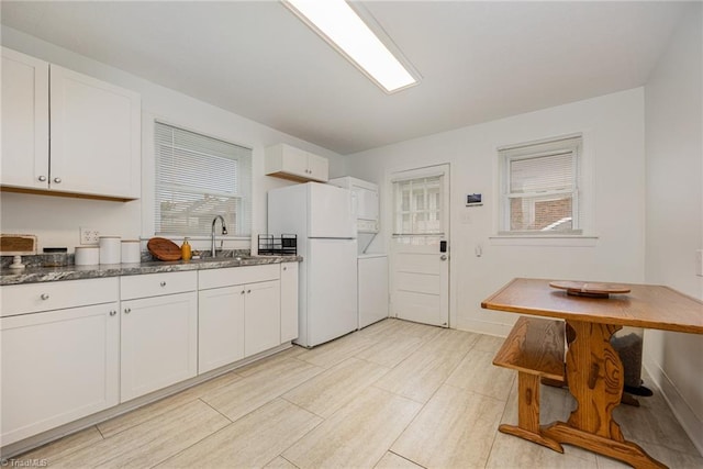 kitchen with sink, white cabinetry, and white refrigerator