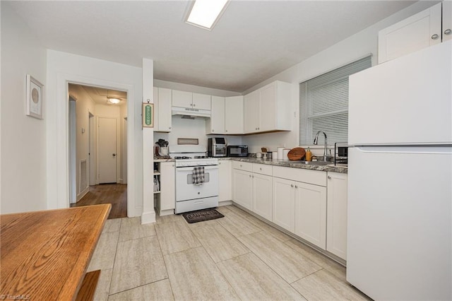 kitchen featuring white cabinetry, sink, white appliances, and dark stone counters