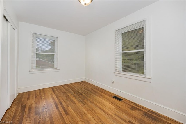 unfurnished room with wood-type flooring